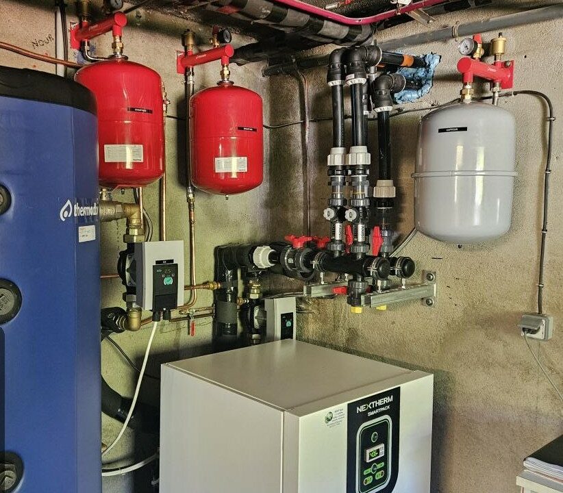 Ballon tampon et pompe à chaleur géothermique Nextherm SmartPack en local technique, réalisation Kraft Géothermie